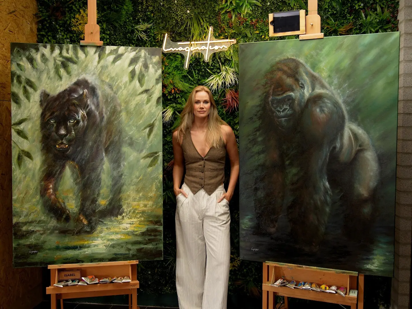 Isabel standing between two of her original paintings